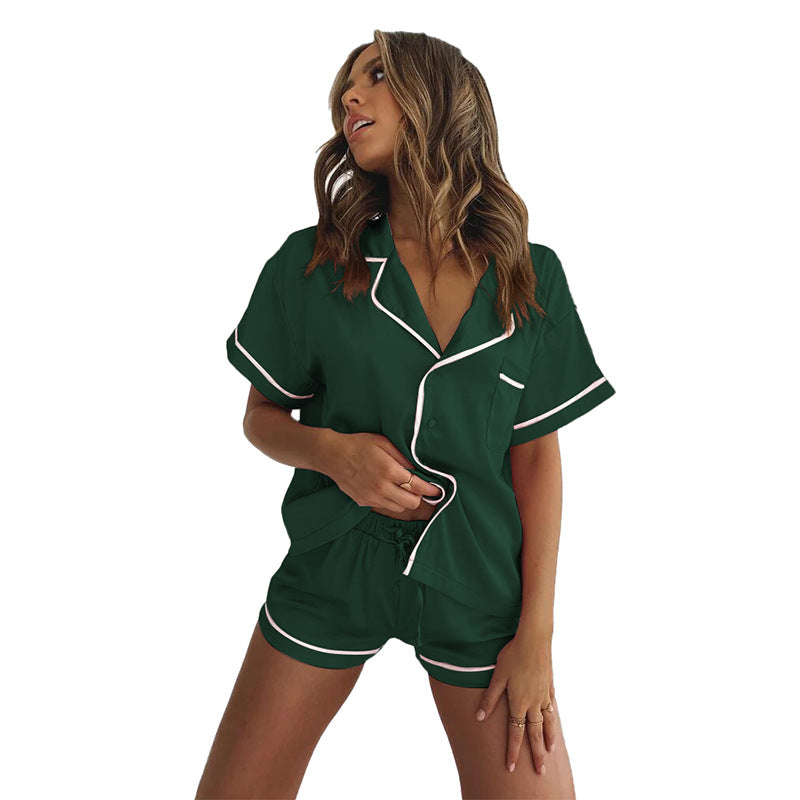 Woman wearing a soft satin pajama set featuring a short-sleeved button-up shirt and matching shorts, available in pink, red, green, black, and blue—lightweight, elegant, and perfect for sleepwear.
