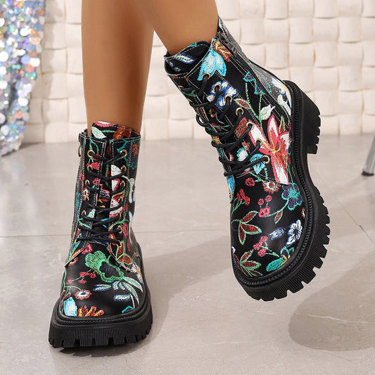 Black combat-style boots with a vibrant floral pattern, black laces, deep-tread black soles, and side zippers—bold, stylish, and perfect for any outfit.