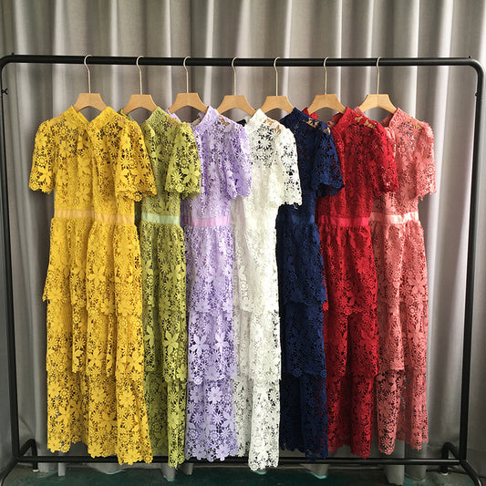 Row of lace dresses in various colors on a rack against a neutral background