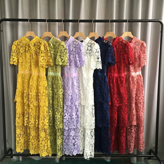 Row of lace dresses in various colors on a rack against a neutral background