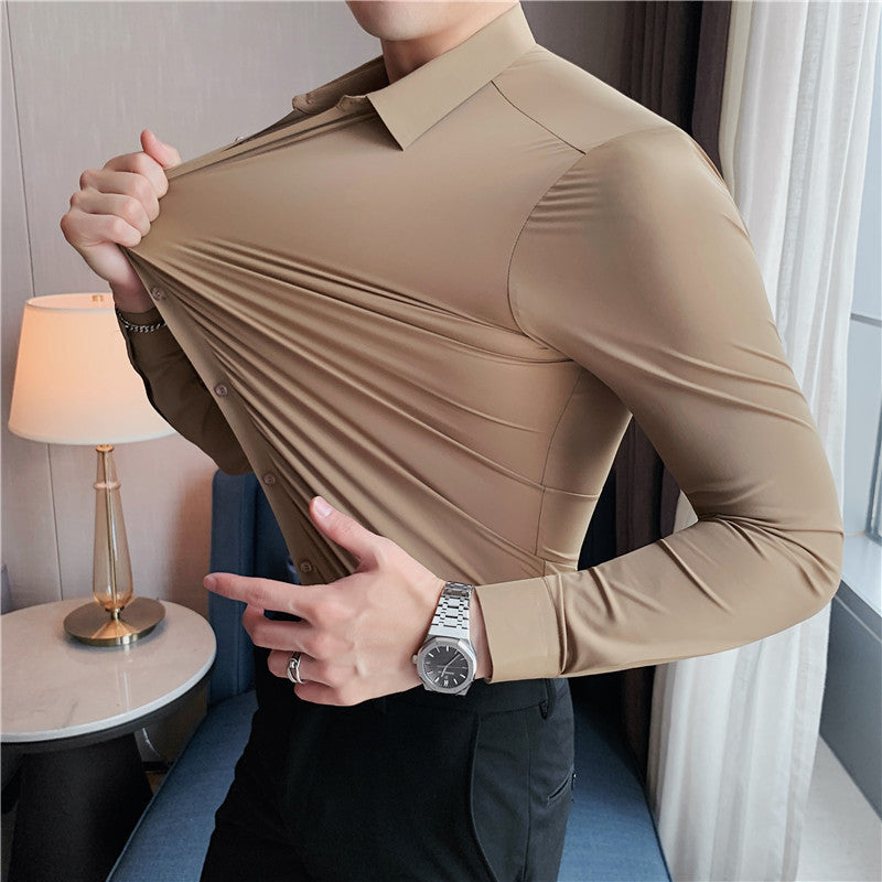 Premium stretch silk men’s long-sleeve button-up shirt in a solid white color, worn by a seated individual, showcasing smooth luxurious fabric and business-ready styling.