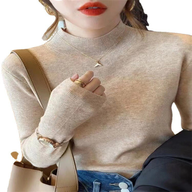 Woman wearing a ribbed light-colored turtleneck sweater, accessorized with hoop earrings, a delicate necklace, and rings—cozy, elegant, and perfect for chilly days.