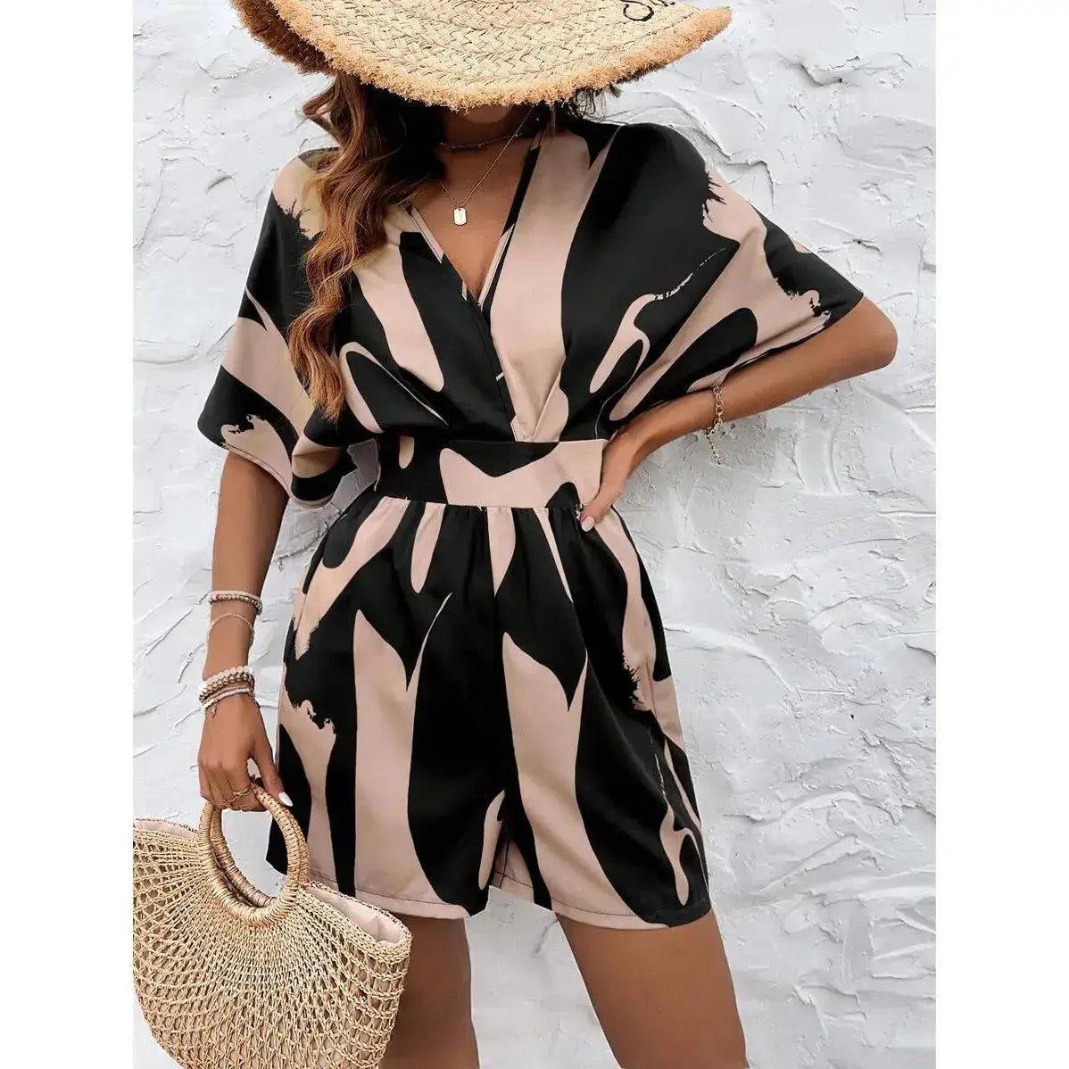 Stylish woman wearing an off-shoulder black jumpsuit with flowing wide-leg pants, posing for a mirror selfie—modern, sophisticated, and effortlessly chic.