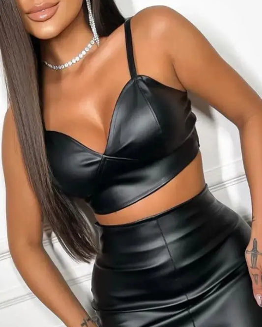 A model wearing a PU leather crop top and high-waist pencil skirt with a front slit, styled with accessories to create a bold, modern look