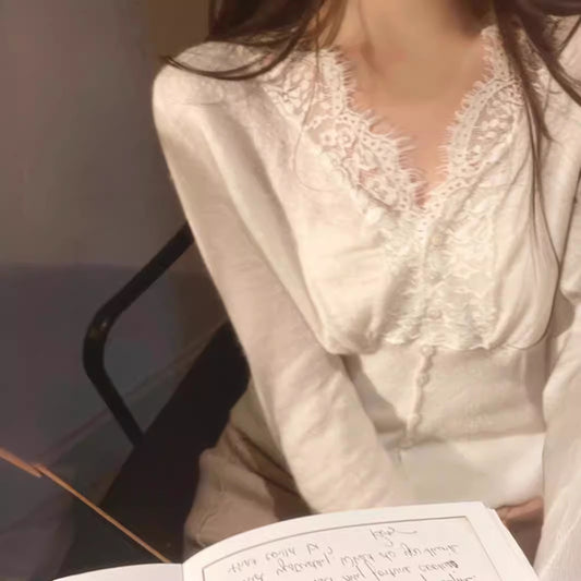 White sweater with intricate floral lace detailing around the neckline and cuffs, styled with delicate accessories—elegant, cozy, and perfect for both casual and dressy outfits.