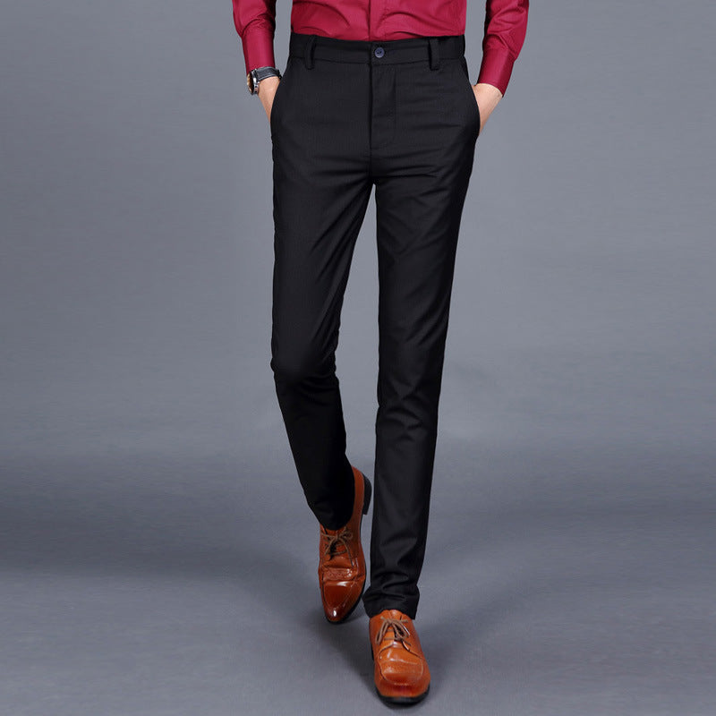 Multiple views of structured tailored trousers in navy, grey, black, and additional colours, styled with a white shirt and brown shoes, highlighting pleats, tapered legs, and buttoned back pockets