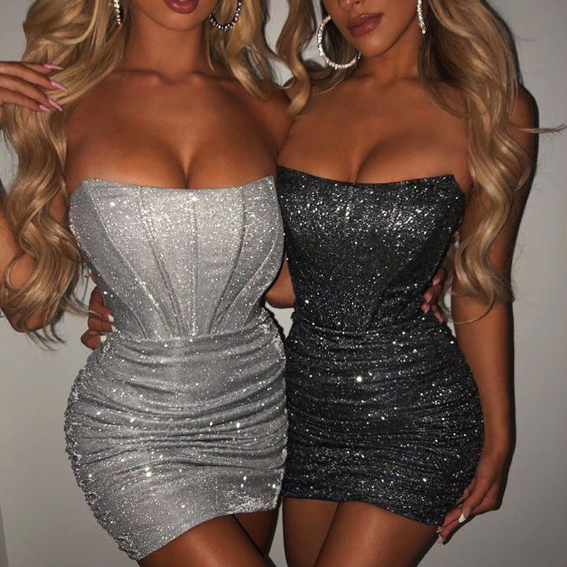 Two women wearing dazzling glitter bodycon dresses – one in silver, one in black – highlighting the fitted silhouette and shimmering fabric