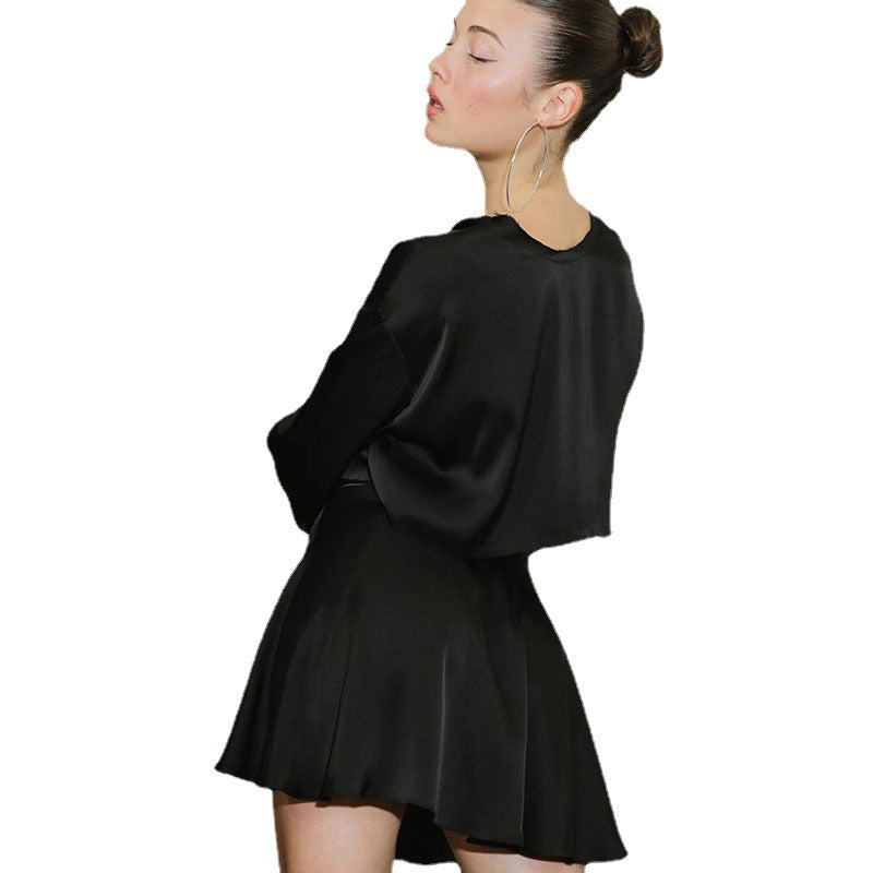 A model wearing a stylish two-piece set, featuring a high-waist tie skirt and a long-sleeved cardigan top, highlighting the flattering fit and elegant draping