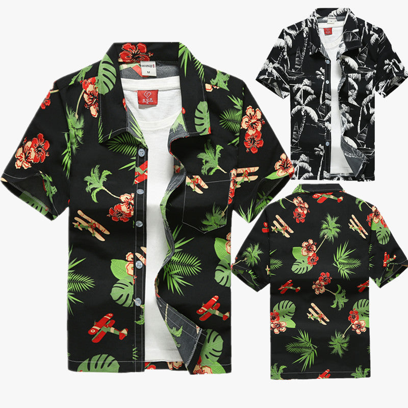 Tropical button-up shirt featuring a black base with green palm leaves, red hibiscus flowers, and airplane motifs, displayed flat to showcase summer-ready, relaxed styling.