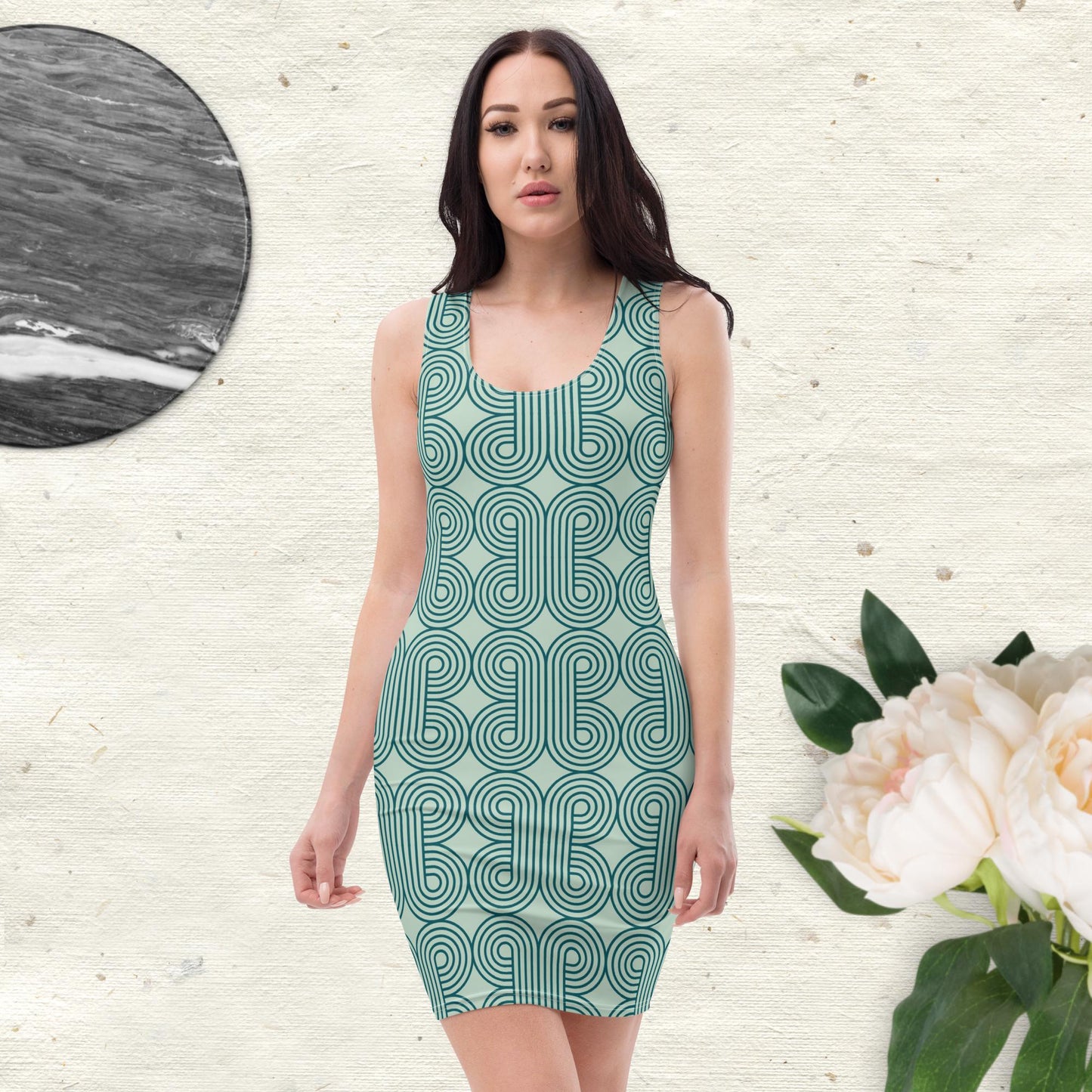 Sleeveless form-fitting dress featuring bold teal curved-line geometric patterns on a light base, paired with chic accessories—modern, artistic, and perfect for stylish wear.