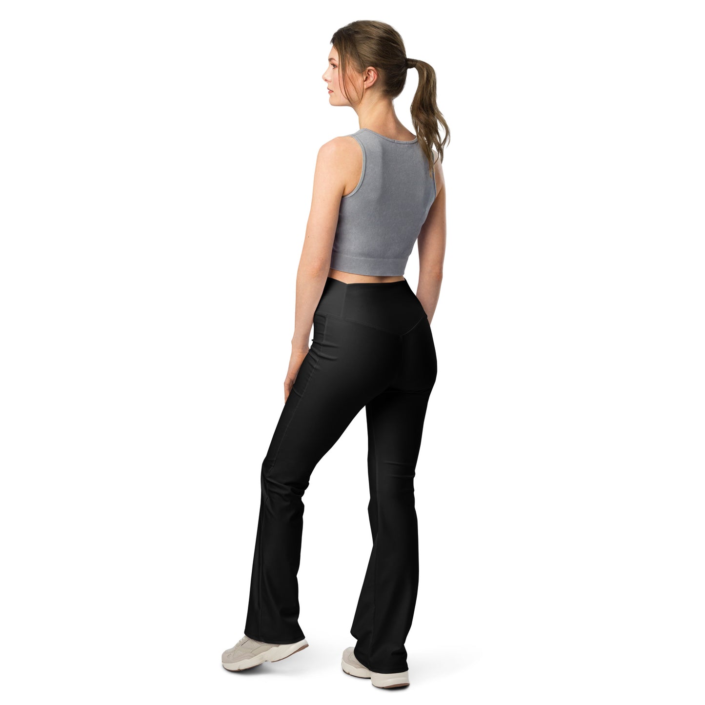 Person wearing black leggings paired with a beige crop top, white button-up jacket, and white sneakers—modern, stylish, and perfect for casual fashion.