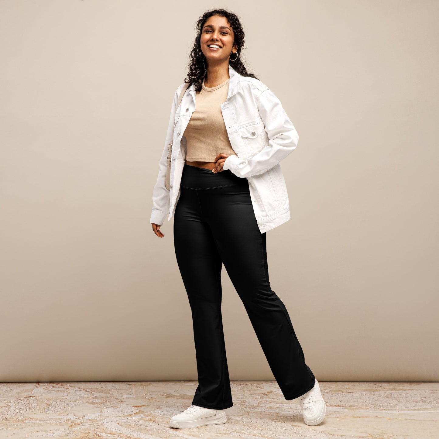 Person wearing black leggings paired with a beige crop top, white button-up jacket, and white sneakers—modern, stylish, and perfect for casual fashion.