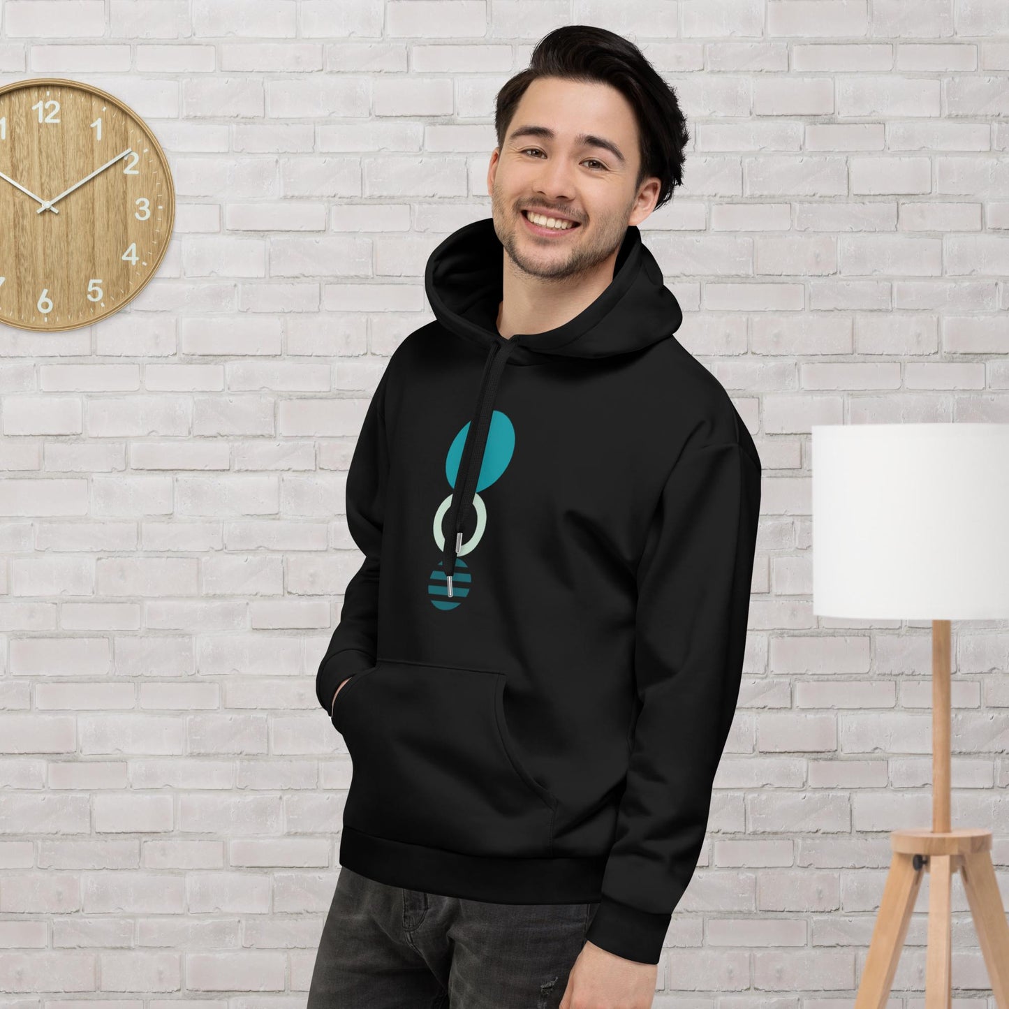 Black hoodie featuring a bold teal and white circular geometric design, with a front pocket and adjustable metal-tipped drawstring hood—modern, stylish, and perfect for everyday wear.