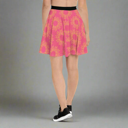 Pink skirt featuring a striking yellow sunburst pattern, paired with a black waistband and athletic shoes—bold, vibrant, and perfect for making a statement.