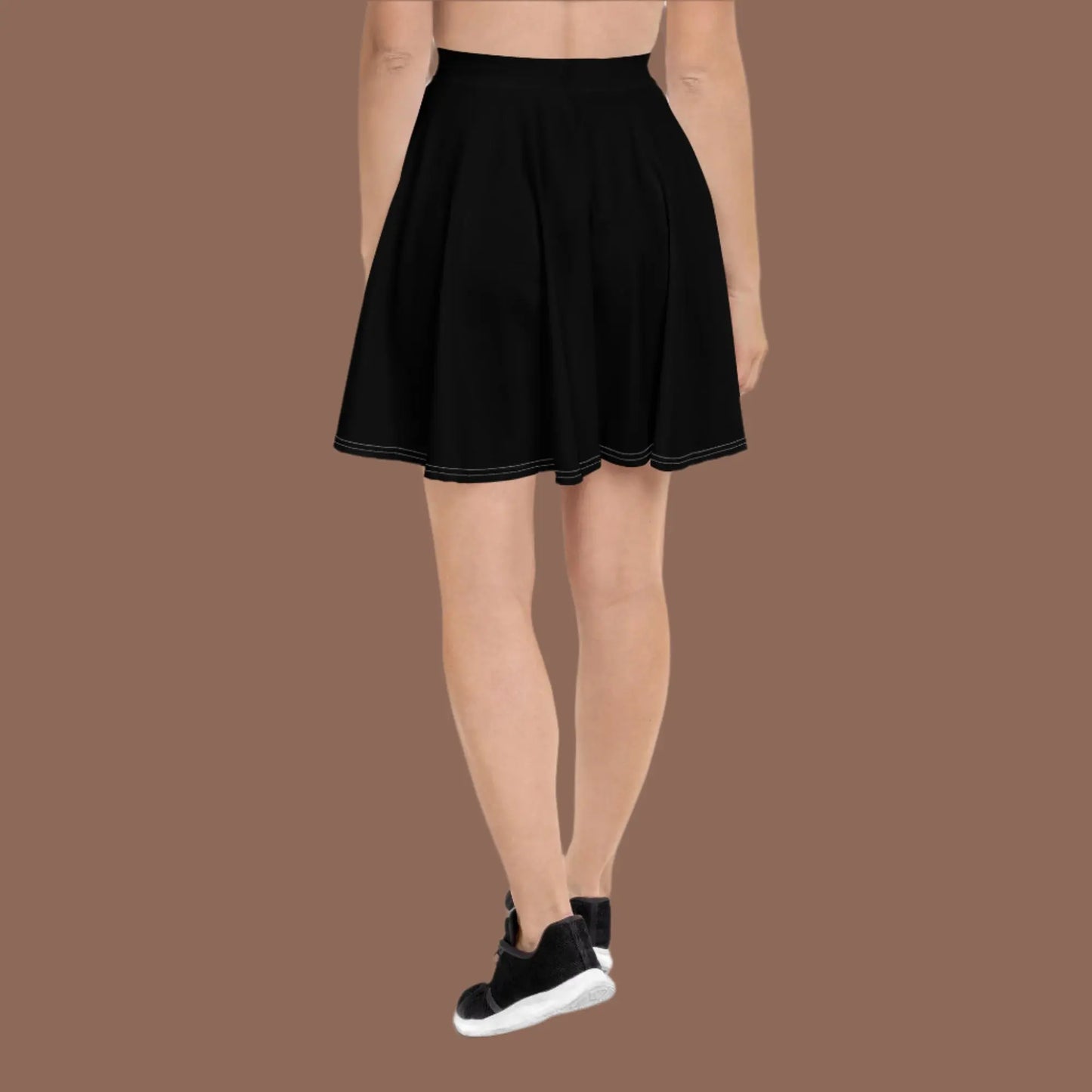 Person wearing a white sleeveless top paired with a black flared skirt and white sneakers—stylish, versatile, and perfect for casual chic wear.