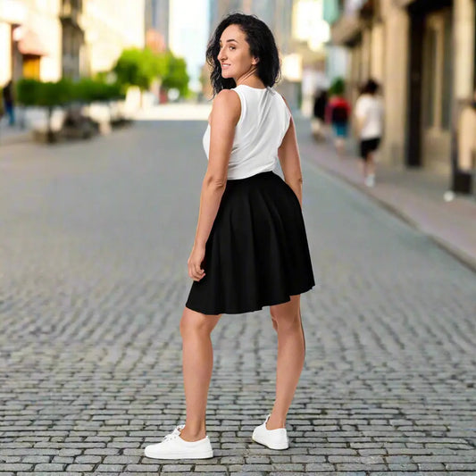 Person wearing a white sleeveless top paired with a black flared skirt and white sneakers—stylish, versatile, and perfect for casual chic wear.