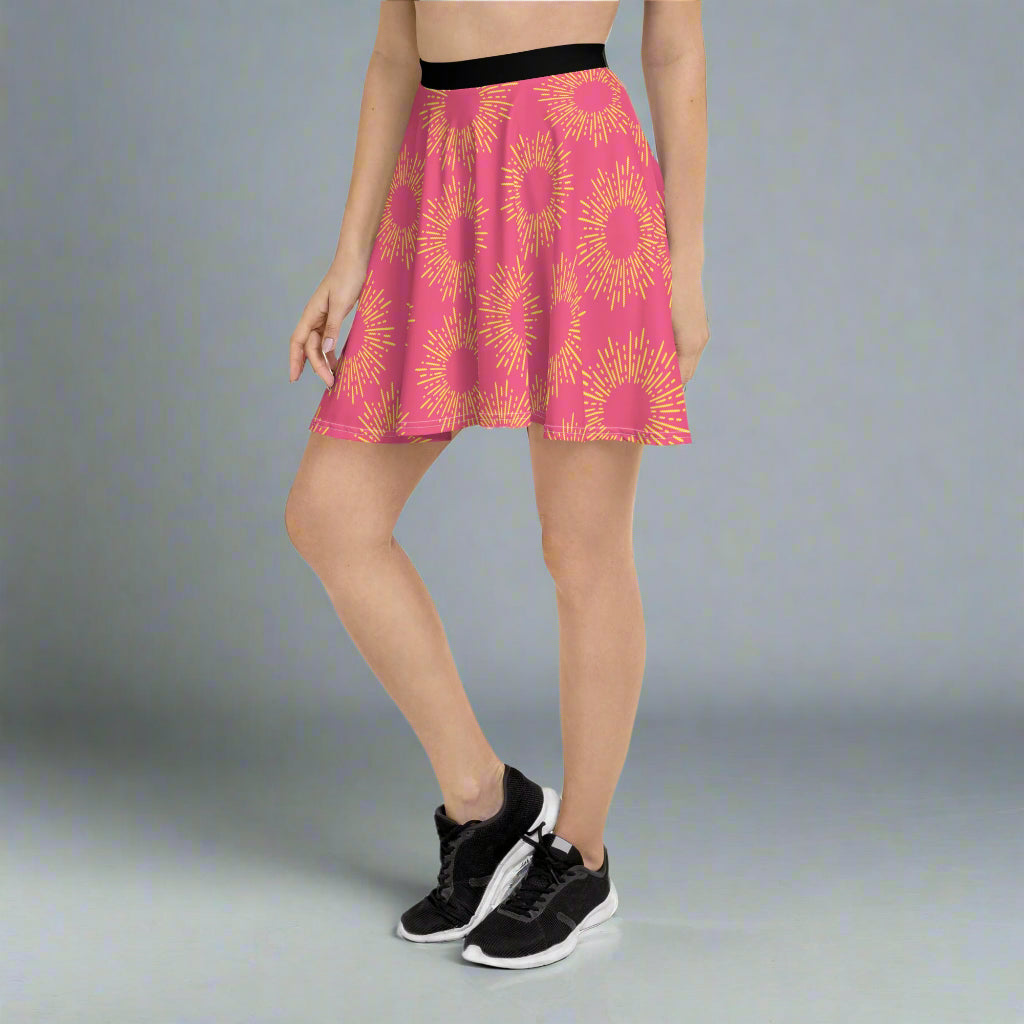 Pink skirt featuring a striking yellow sunburst pattern, paired with a black waistband and athletic shoes—bold, vibrant, and perfect for making a statement.