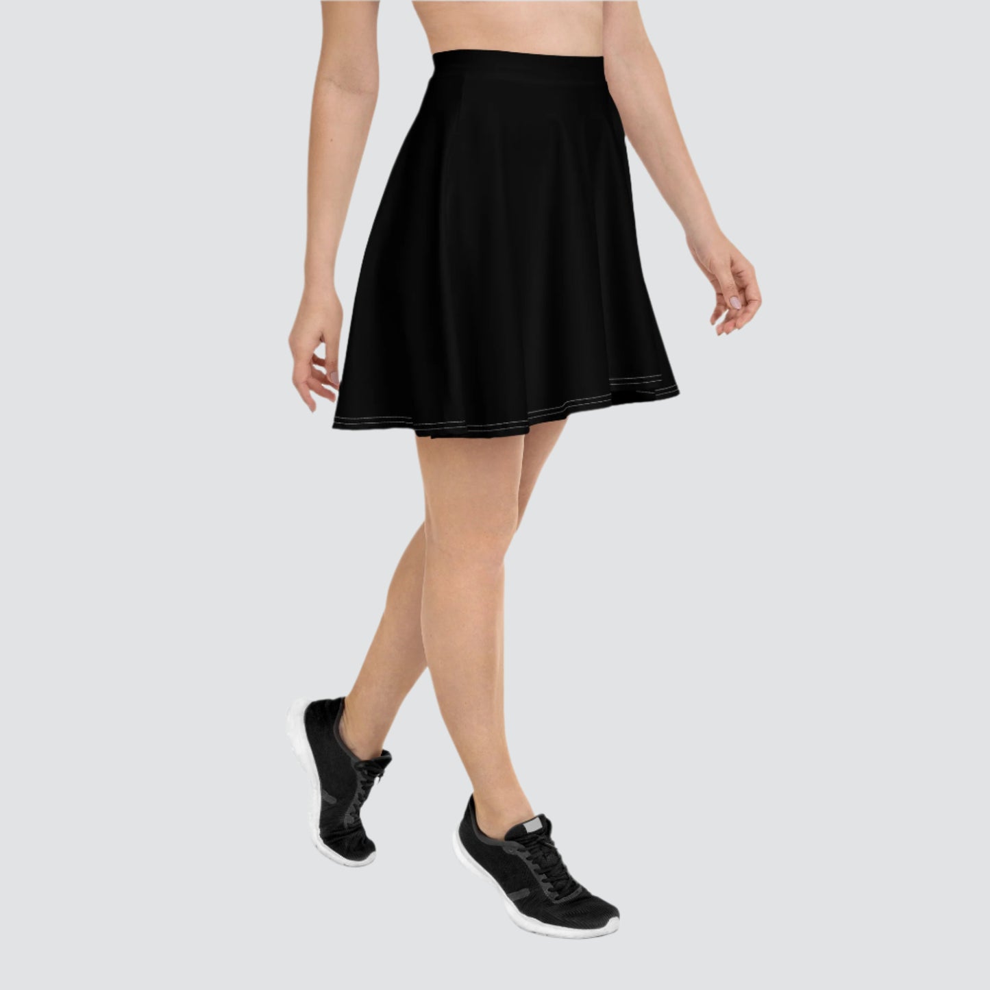 Person wearing a white sleeveless top paired with a black flared skirt and white sneakers—stylish, versatile, and perfect for casual chic wear.