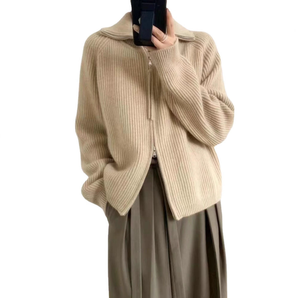 Woman wearing a beige ribbed knit sweater with a high collar and a partially zipped front, styled with light pink pants and delicate accessories—cozy, stylish, and perfect for layering.