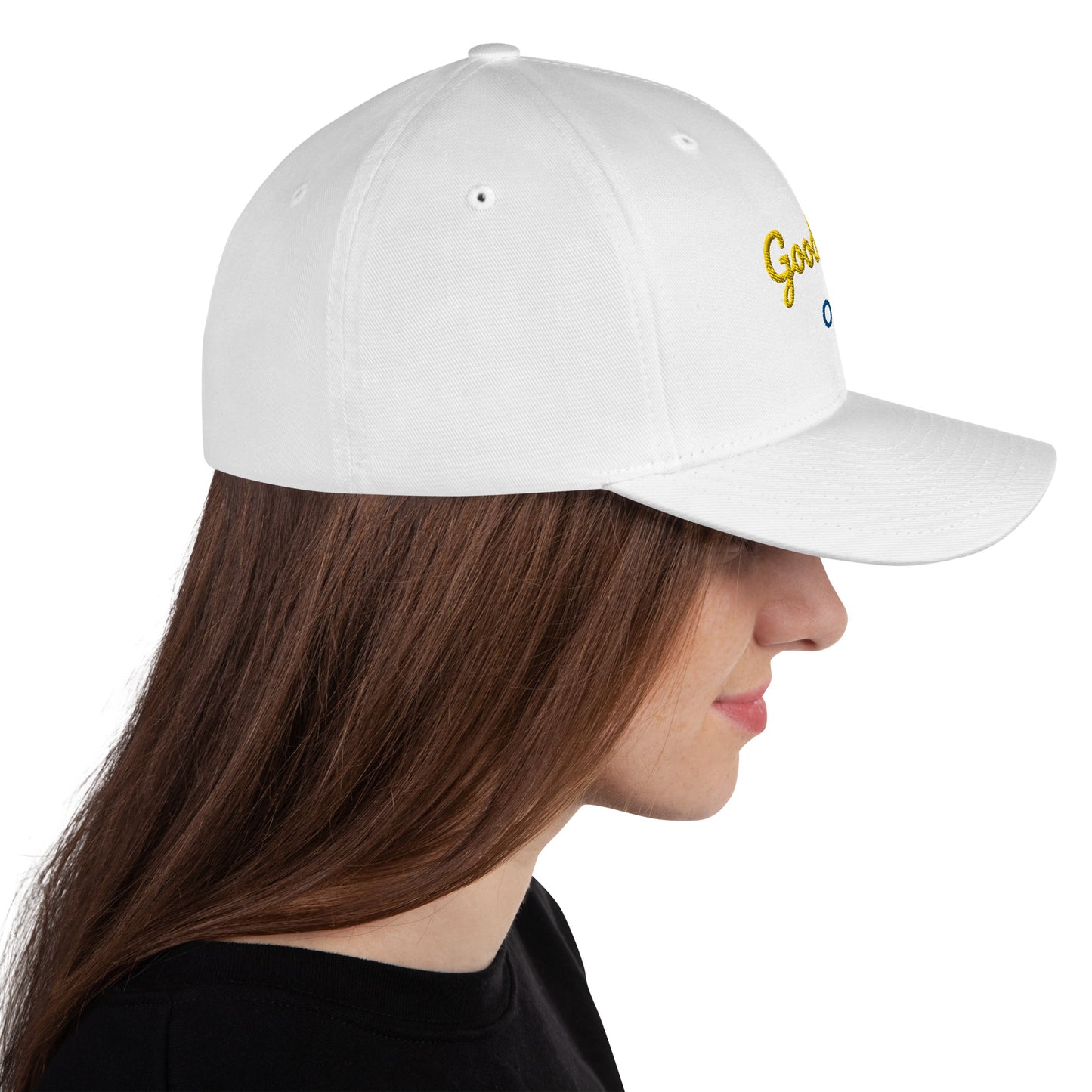 White baseball cap featuring embroidered text reading ‘GOOD VIBES ONLY’ in yellow, placed beside black headphones and stationery—modern, stylish, and perfect for casual wear.
