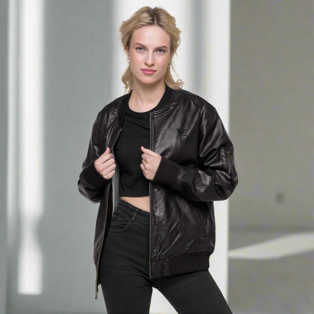 Black faux leather jacket with ribbed cuffs and hem, a zip-up front, soft grey inner lining, and a small embroidered deer logo on the chest—stylish, structured, and perfect for casual or dressy outfits.