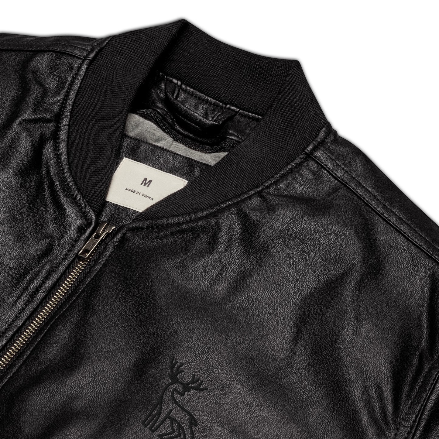 Black faux leather jacket with ribbed cuffs and hem, a zip-up front, soft grey inner lining, and a small embroidered deer logo on the chest—stylish, structured, and perfect for casual or dressy outfits.