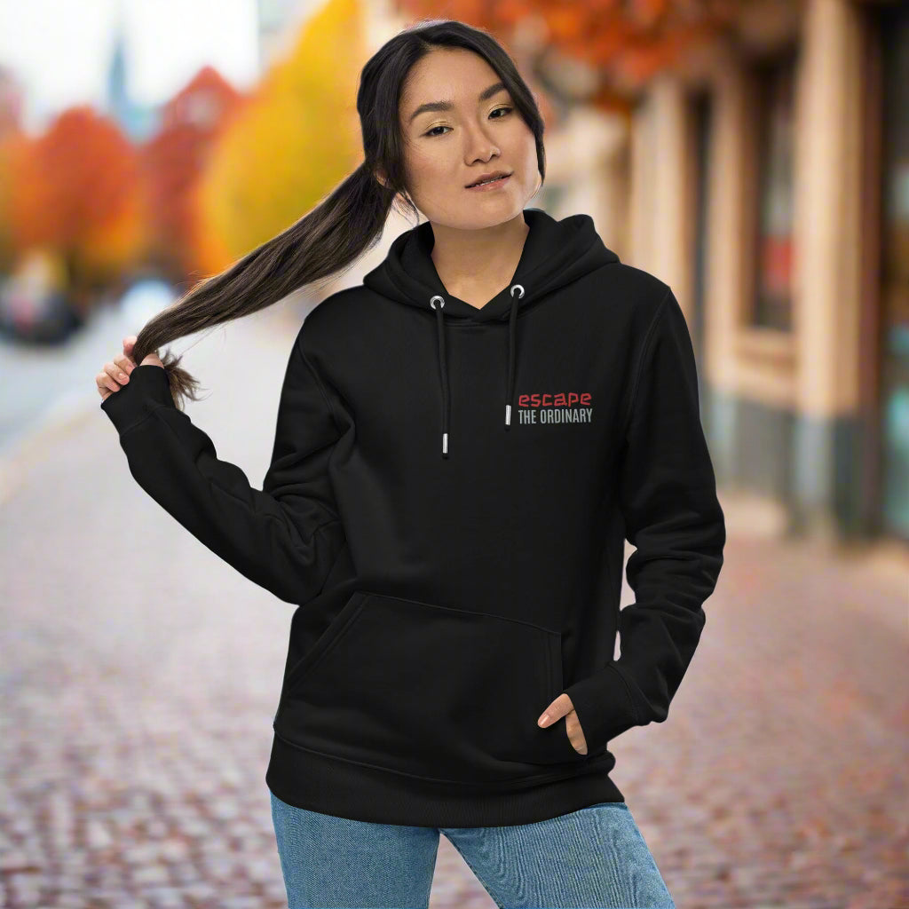 Minimalist street-style hoodie available in navy blue, black, and white, featuring a bold text design on the chest reading ‘escape’ in red and ‘THE ORDINARY’ in white, along with a front pocket and adjustable metal-tipped drawstring hood.