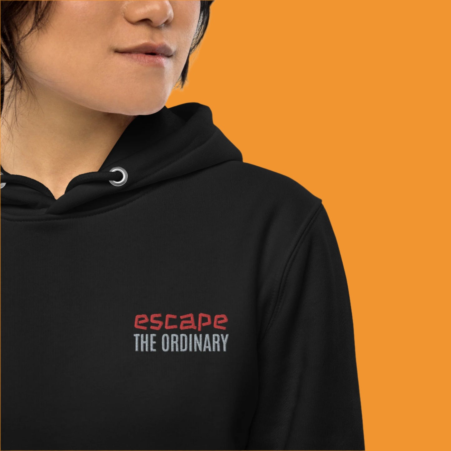 Minimalist street-style hoodie available in navy blue, black, and white, featuring a bold text design on the chest reading ‘escape’ in red and ‘THE ORDINARY’ in white, along with a front pocket and adjustable metal-tipped drawstring hood.