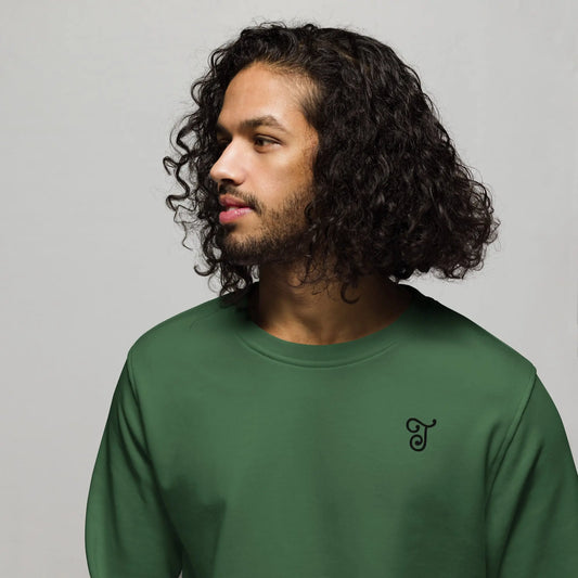 Green sweatshirt featuring an embroidered letter ‘T’ on the left chest, worn with beige pants, seated on a black stool against a white background—modern, stylish, and available in multiple colors.