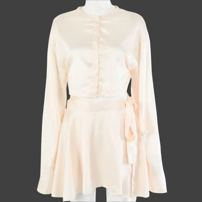A model wearing a stylish two-piece set, featuring a high-waist tie skirt and a long-sleeved cardigan top, highlighting the flattering fit and elegant draping
