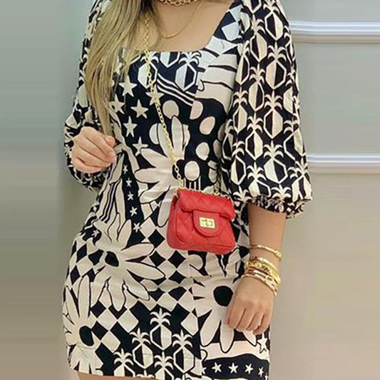 Person wearing a silk dress with black and white geometric patterns, featuring a square neckline and puffed sleeves.
