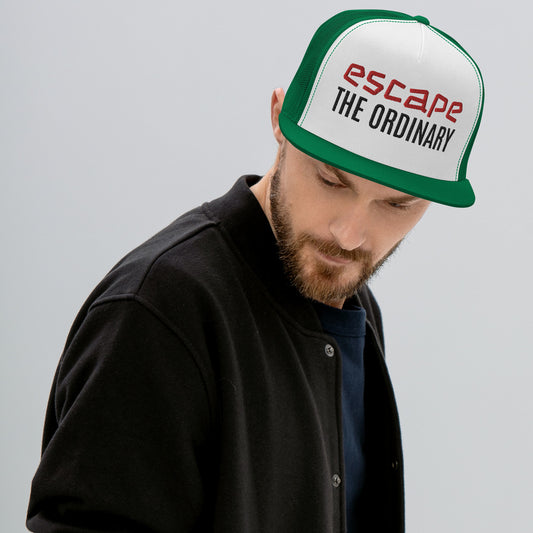 Green-brim trucker hat featuring a white front panel embroidered with ‘escape THE ORDINARY’ text in red and black, worn with a black jacket—stylish, bold, and perfect for casual street-style fashion.