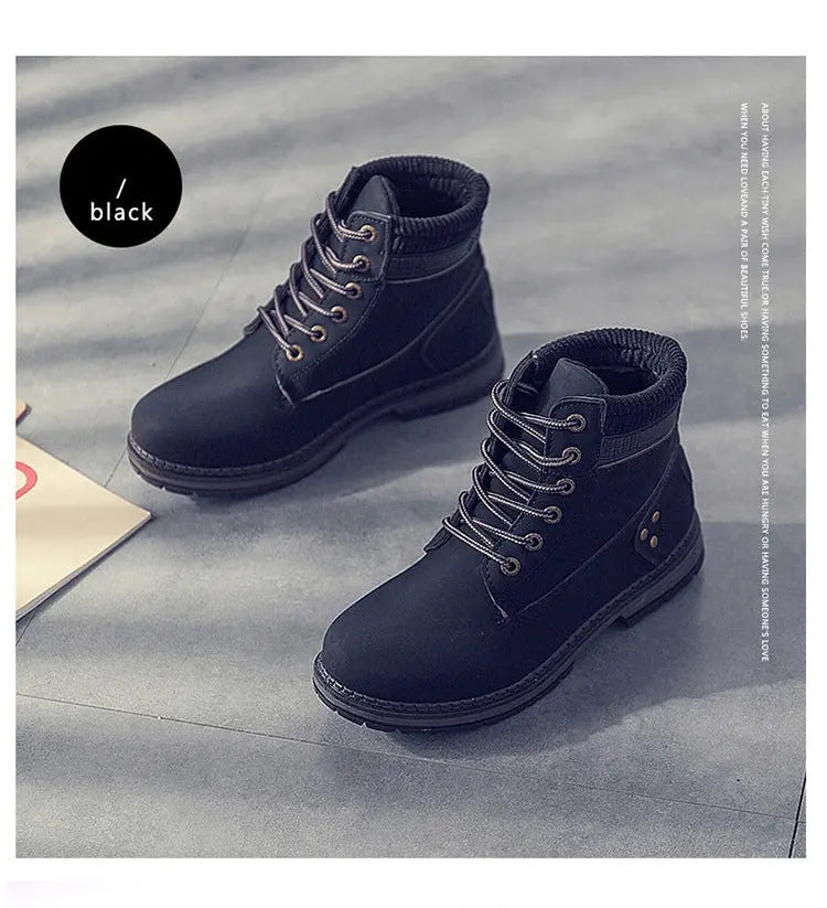 A pair of dark navy blue lace-up ankle boots with black soles, displayed on a gray textured floor. A black circular label on the left reads '黑色 / black'.