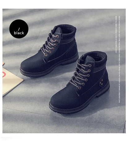 A pair of dark navy blue lace-up ankle boots with black soles, displayed on a gray textured floor. A black circular label on the left reads '黑色 / black'.