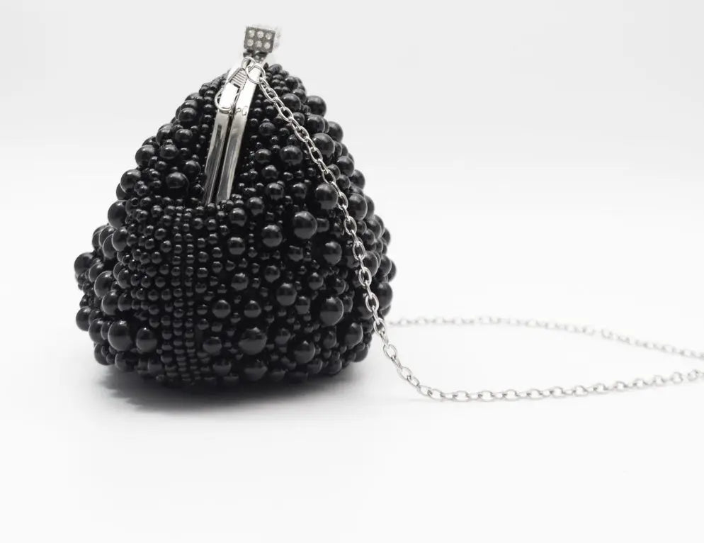 A black beaded evening clutch purse with a silver-tone metal clasp and a delicate silver chain strap, photographed on a clean white background.