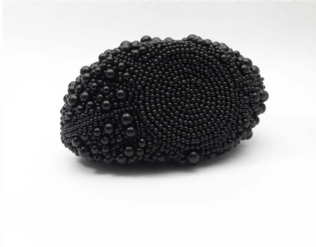 A black beaded oval clutch purse with a textured, raised bead pattern, photographed on a clean white background.