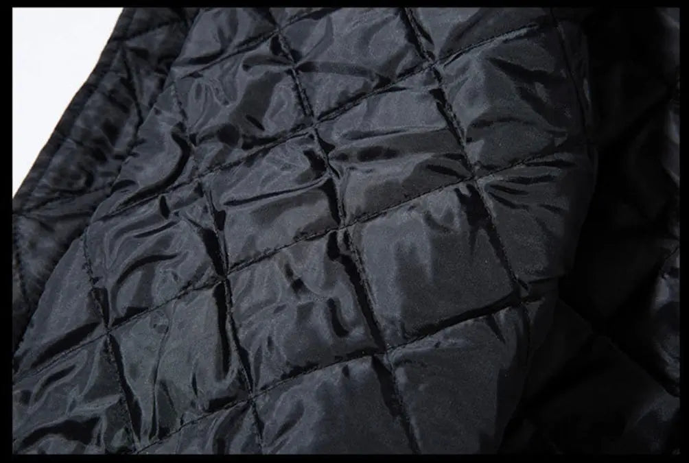 Close-up of a black quilted jacket or padded fabric with a glossy finish and stitched diamond pattern.