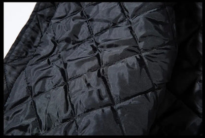 Close-up of a black quilted jacket or padded fabric with a glossy finish and stitched diamond pattern.