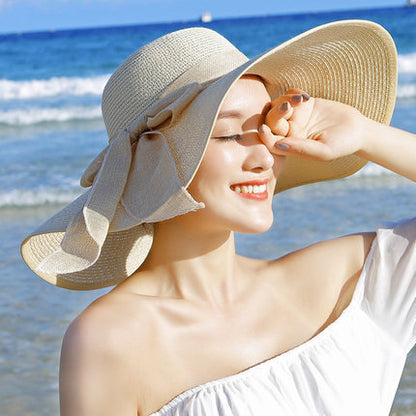 Elegant wide-brim sun hat with a bow detail, available in multiple colors including beige, black, white, pink, and blue—stylish, lightweight, and perfect for sunny days.