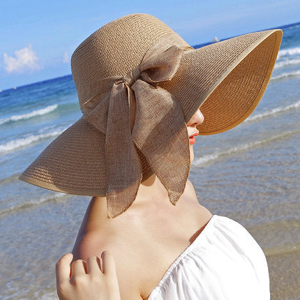 Elegant wide-brim sun hat with a bow detail, available in multiple colors including beige, black, white, pink, and blue—stylish, lightweight, and perfect for sunny days.