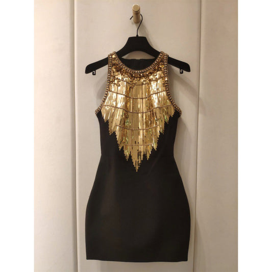 Black sleeveless mini dress with intricate gold sequins and fringe embellishments, styled for a glamorous evening look