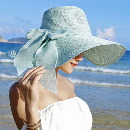 Elegant wide-brim sun hat with a bow detail, available in multiple colors including beige, black, white, pink, and blue—stylish, lightweight, and perfect for sunny days.