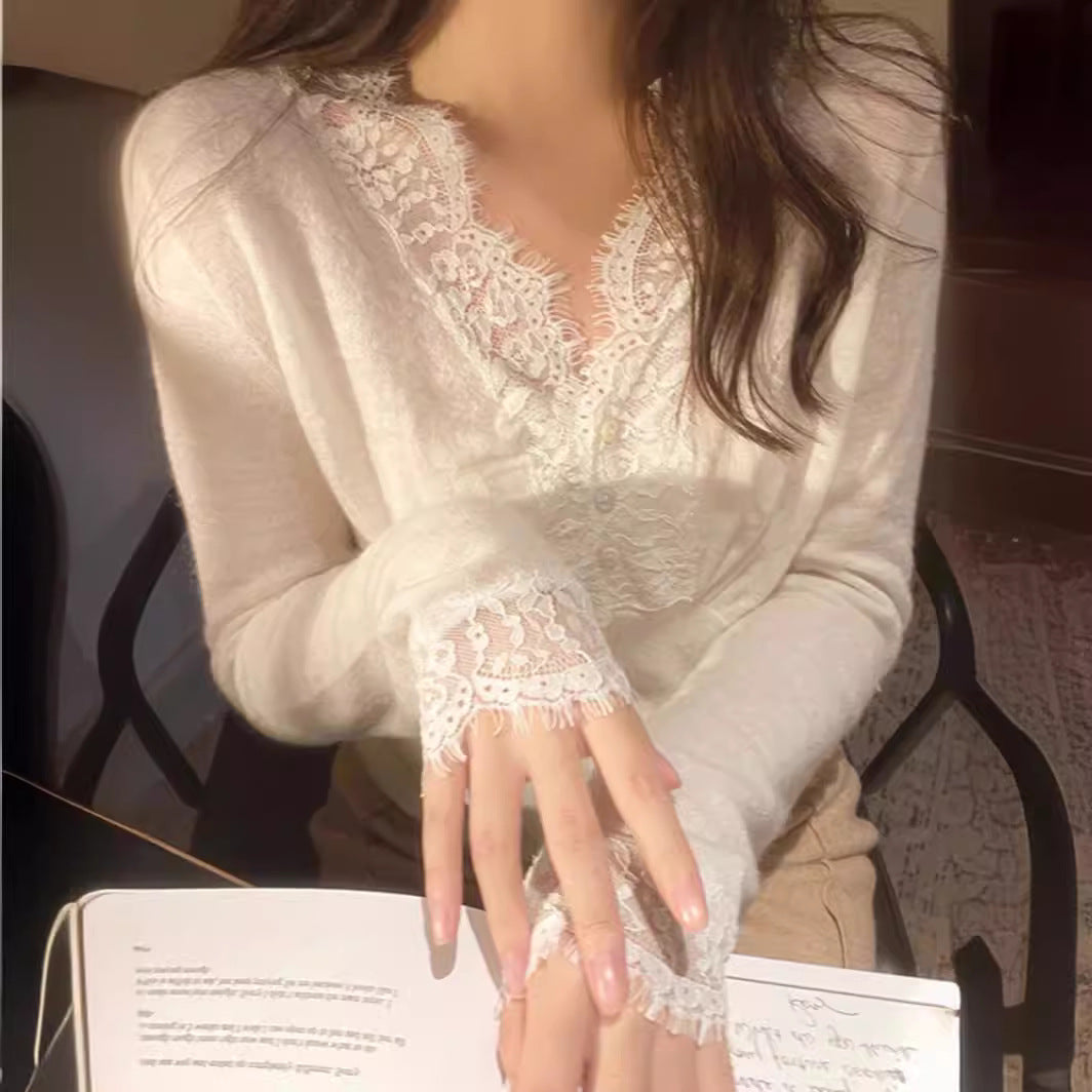 White sweater with intricate floral lace detailing around the neckline and cuffs, styled with delicate accessories—elegant, cozy, and perfect for both casual and dressy outfits.