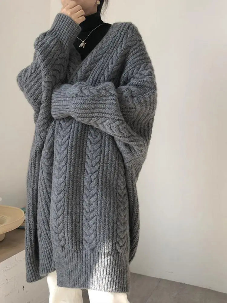 Gray knitted cardigan worn by a person on a plain background
