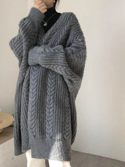 Gray knitted cardigan worn by a person on a plain background