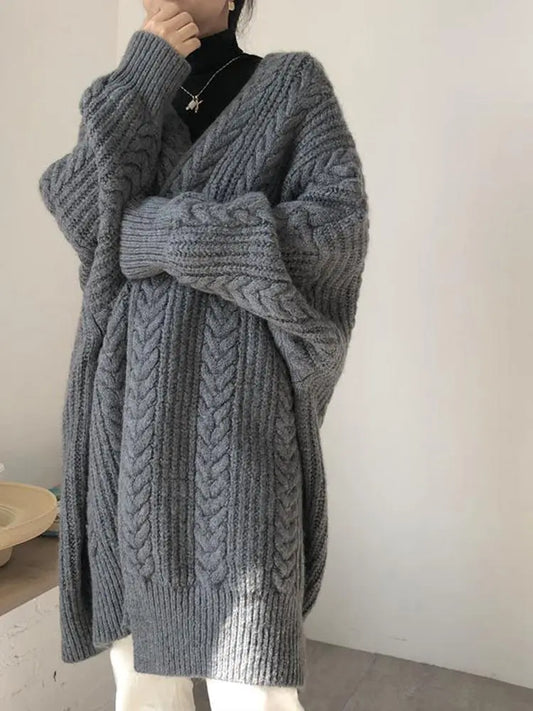 Gray knitted cardigan worn by a person on a plain background
