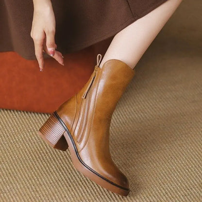 Brown leather ankle boot worn by a person on a textured surface