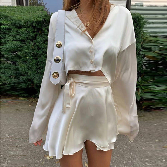 A model wearing a stylish two-piece set, featuring a high-waist tie skirt and a long-sleeved cardigan top, highlighting the flattering fit and elegant draping