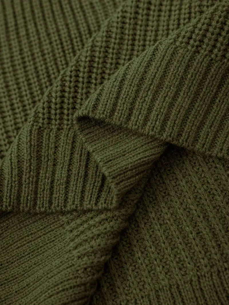 Close-up of olive green ribbed knit fabric with a textured waffle pattern, showing folds and drapery.