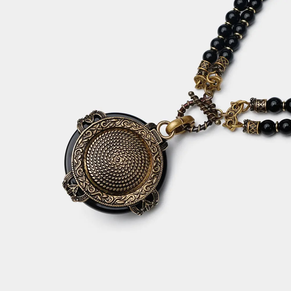Vintage bee pendant necklace with natural black agate beads and antique copper detailing.